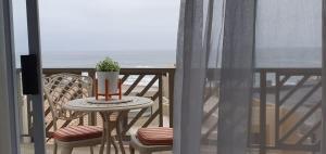 a table and chairs on a balcony with the ocean at CUTTY SARK in Langstrand