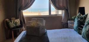 a bedroom with a bed with a window and a box at Dolphin View 20 @ LongBeach in Langstrand