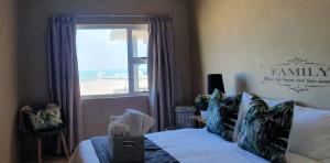 a bedroom with a bed and a window with a view at Dolphin View 20 @ LongBeach in Langstrand