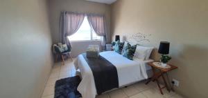 a bedroom with a bed and a window at Dolphin View 20 @ LongBeach in Langstrand