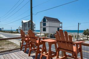 a table and chairs on a deck with the beach at Steps to the Beach 3BR Coastal Home Sleeps 10 in Port Saint Joe