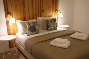 a bedroom with a large bed with two towels on it at Olívale - Turismo Rural in Campo Maior +73 photos