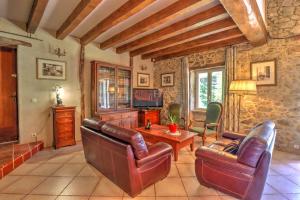 a living room with leather furniture and a tv at Le Triol in Les Fournials
