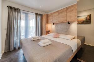 a bedroom with a large bed with two towels on it at Sea view SanNor by Vellaris, Luxury Mobile Home in Mali Lošinj