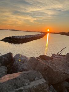 a sunset over a body of water with rocks at Villa Emily appartamento in Ca Tiepolo