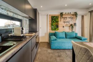 a kitchen and living room with a blue couch at Sea view SanNor by Vellaris, Luxury Mobile Home in Mali Lošinj