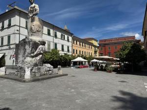 a statue in the middle of a courtyard with buildings at SOBBORGO 34 - Affittacamere - in Sarzana