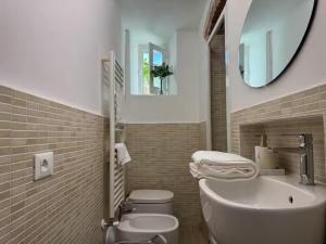 a bathroom with a toilet and a sink and a mirror at SOBBORGO 34 - Affittacamere - in Sarzana +5 photos