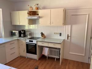 a kitchen with white cabinets and a stove top oven at Landhuus Stender in Eutin +19 photos