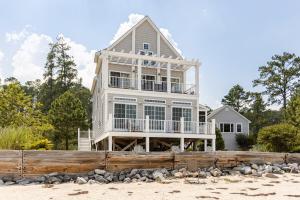 a large house on the beach with a wooden fence at L'Hermione in Gloucester