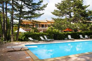 a pool with chairs and a house in the background at lou pèbre d'aï in Plan dʼAups
