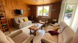 a living room with two couches and a table at Paisible in La Celle-sous-Gouzon