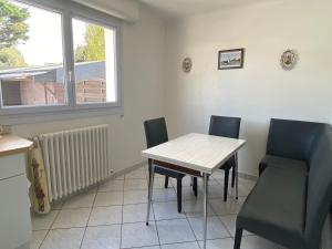a dining room with a table and chairs and a window at Paisible in La Celle-sous-Gouzon