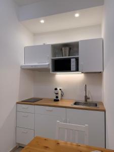 a small kitchen with white cabinets and a sink at Suite 55 in Trani