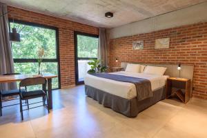 a bedroom with a bed and a brick wall at H5063 in Buenos Aires