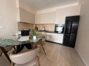 a kitchen with a dining table and a black refrigerator at Everbright Seaside Serenity in Himare