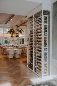 a dining room with tables and a large wine cellar at Boutique Hotels MANNA & Blue in Nijmegen
