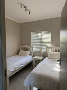 two beds in a small room with a window at Dolphin View 32 in Langstrand