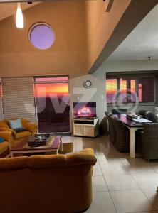 a living room with a couch and a tv at Dolphin View 32 in Langstrand