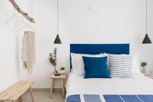 a bedroom with a bed with blue and white pillows at O Lugar in Porto Covo