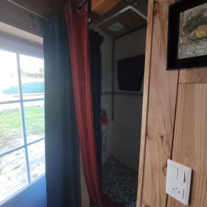a small bathroom with a door and a mirror at La Lézardière in Saint-Germain-sur-École
