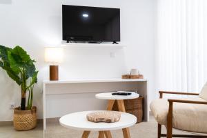 a living room with a couch and a tv on a wall at Big Waves Retreat Nazaré - By Nest & Co in Nazaré