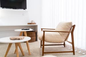a living room with a chair and a tv at Big Waves Retreat Nazaré - By Nest & Co in Nazaré