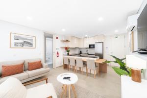 a living room and kitchen with a couch and a table at Big Waves Retreat Nazaré - By Nest & Co in Nazaré