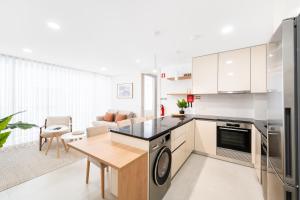 a kitchen and living room with a table and a stove at Big Waves Retreat Nazaré - By Nest & Co in Nazaré +28 photos