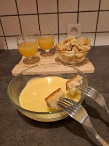 a plate with a piece of cake and two glasses of orange juice at MON SKI A LA PLAGNE - PLAGNE BELLECOTE Résidence 3000 in Plagne Bellecote