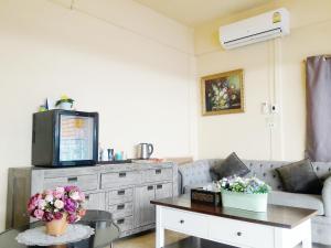 a living room with a couch and a table at Navavilla Serviced Apartment in Ban Lam Rua Taek