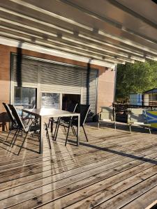 a patio with a table and chairs on a deck at Splav La-familia in Umka