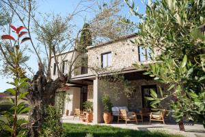 a brick house with a patio and trees at Képos Villas Sivota in Syvota +11 photos