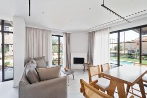 a living room with a table and chairs and a dining room at Képos Villas Sivota in Syvota