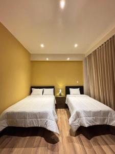 two beds sitting next to each other in a room at Terrazas 3400 Lodge in Oxapampa