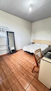 a bedroom with a bed and a table and a chair at Casa próxima ao Centro de Foz in Foz do Iguaçu