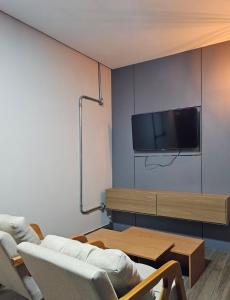a living room with a couch and a tv on a wall at D Castro Residencial in Montes Claros