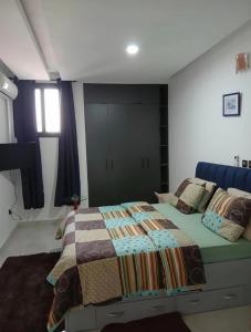a bedroom with a bed with a quilt on it at le laurier 9 in Abidjan