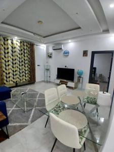 a living room with a glass table and white chairs at le laurier 9 in Abidjan