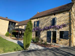 a house with purple flowers on the side of it at Cottage de La Mothe in Marnac