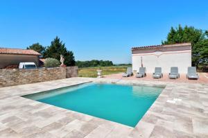 a swimming pool with chairs and a house at Le Triol in Les Fournials