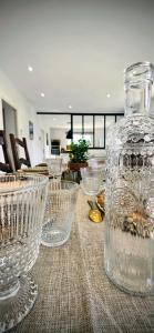 a table with glass bowls and a large glass jar on it at Villa Elara provençale avec piscine 4 étoiles in Sarrians