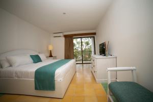 a bedroom with a bed and a television in it at Hotel Croma Sosua Beach in Sosúa
