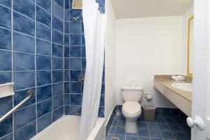 a blue tiled bathroom with a toilet and a bath tub at Hotel Croma Sosua Beach in Sosúa +46 photos