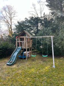 a playground with a slide and a swing at Forest Haus in Schlangenbad