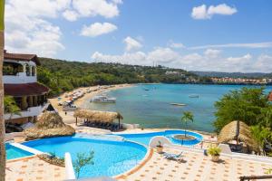 a view of a beach from a resort with two pools at Hotel Croma Sosua Beach in Sosúa