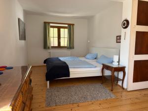 a bedroom with a bed with blue sheets and a window at Nusshof in Berchtesgaden