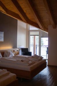 a bedroom with a large bed and a chair at Hotel Auwirt Zentrum in Saalbach-Hinterglemm +53 photos