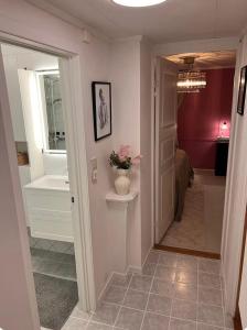 a hallway with a bathroom with a tub and a sink at The Old Bakery in Grimstad +22 photos