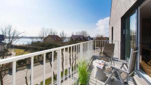 a balcony with two chairs and a view of the water at Apartament 19A - Villa Neptun in Gdańsk